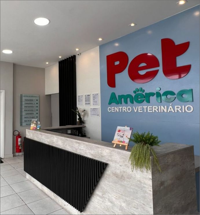 Recepção do Centro Veterinário Pet América, com o logotipo na parede e o balcão de atendimento